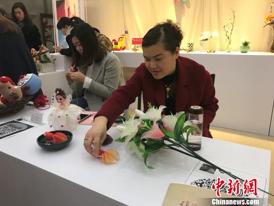 图为女性现场展示手工艺品制作。 钟欣 摄 图为女性现场展示手工艺品制作。 钟欣 摄